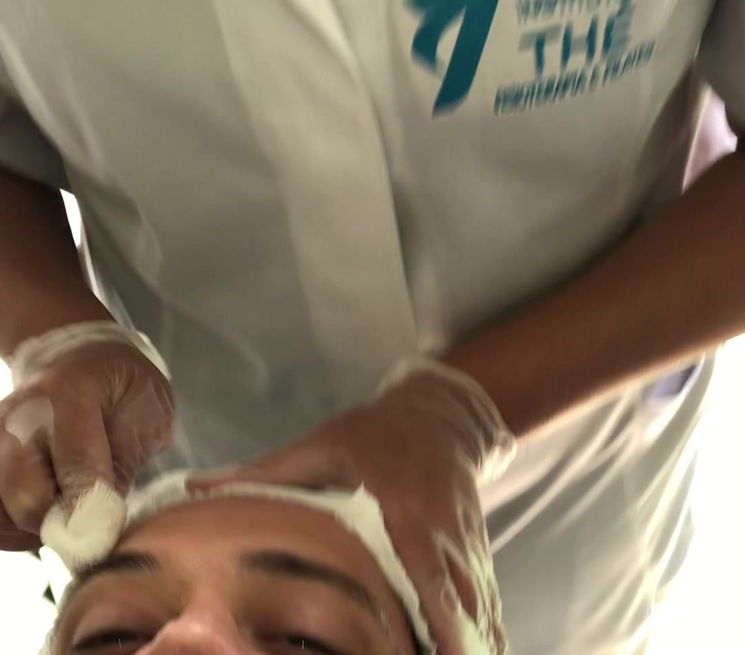 Profissional do Instituto Thé realizando limpeza de pele
